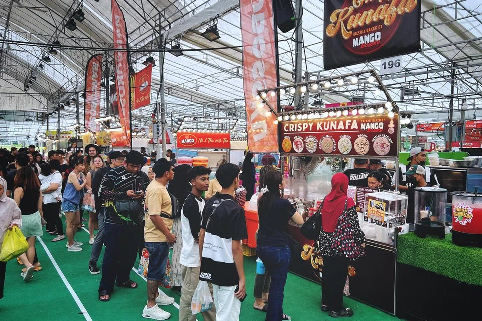 Pelanggan beratur panjang di gerai Crispy Kunafa Mango Bossku di bazar Hari Raya Geylang Serai.