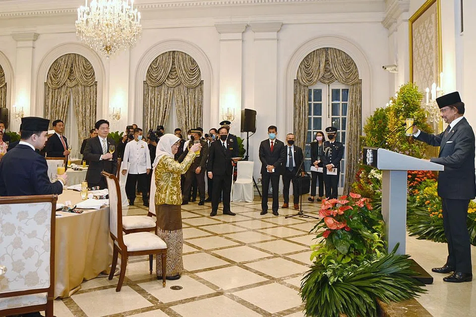 HUBUNGAN LEBIH KUKUH: Minum ucap selamat daripada Sultan Hassanal (kanan) kepada Presiden Halimah Yacob (berbaju kuning) dan tetamu semasa Majlis Jamuan Negara di Dewan Banquet di Istana. - Foto BH oleh DESMOND WEE 