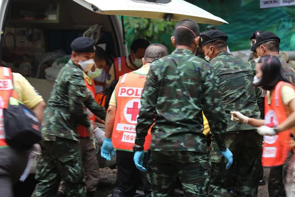 SELAMAT: Gambar yang diambil dan diedarkan oleh Pejabat Perhubungan Awam Chiang Rai menunjukkan askar dan paramedik Thai membantu seorang budak yang diselamatkan dari gua Tham Luang kelmarin masuk ke dalam ambulans bagi dikejarkan ke hospital. - Foto AFP