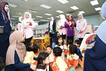 BERSIH DAN SELAMAT: Pengunjung daripada Pusat Pendidikan Butterfly semasa sesi pembacaan buku di Pusat Penjagaan Kanak-Kanak Huda.