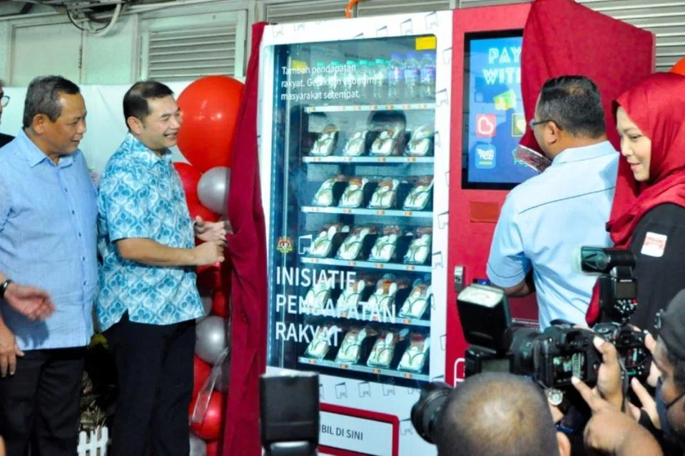 Menteri Ekonomi, Encik Rafizi Ramli (dua dari kiri), ketika meninjau mesin layan diri  menerusi projek Inisiatif Pendapatan Rakyat (IPR) yang dijalankan sebagai usaha membasmi kemiskinan dan menambah pendapatan rakyat.