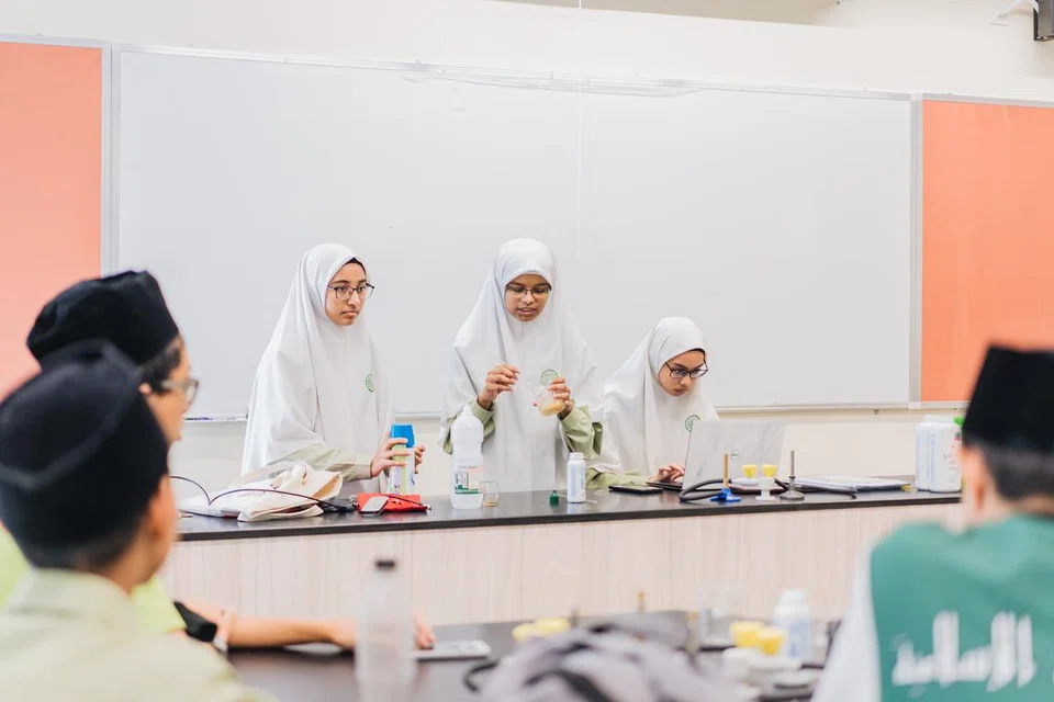 Pelajar membentangkan eksperimen Sains mereka dengan bersungguh-sungguh. 