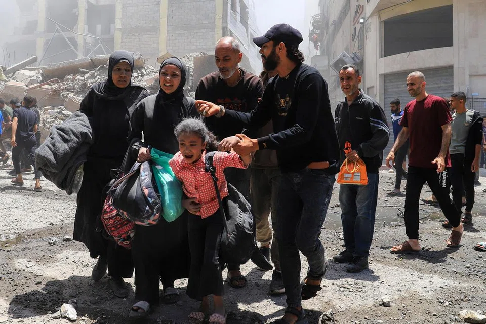Para penduduk membantu mereka yang terjejas akibat pengeboman tentera Israel di Bandar Gaza pada 30 Mei 2025.