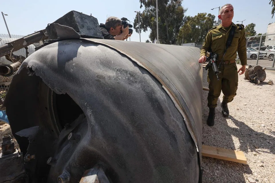 Jurucakap tentera Israel, Laksamana Muda Daniel Hagari (kanan) memeriksa peluru berpandu balistik Iran yang jatuh dalam wilayah Israel ketika serangan berlaku pada malam 13 April.