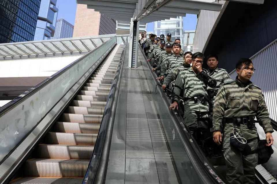 Polis Hong Kong berdiri di tangga bergerak, mengawal keadaan. - Foto REUTERS