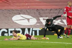 DETIK PENTING: Pemain Burnley, Ashley Barnes terbaring di dalam kotak penalti selepas dikasari penjaga gawang Liverpool Alisson Becker. - Foto REUTERS