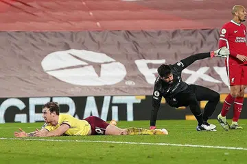 DETIK PENTING: Pemain Burnley, Ashley Barnes terbaring di dalam kotak penalti selepas dikasari penjaga gawang Liverpool Alisson Becker. - Foto REUTERS