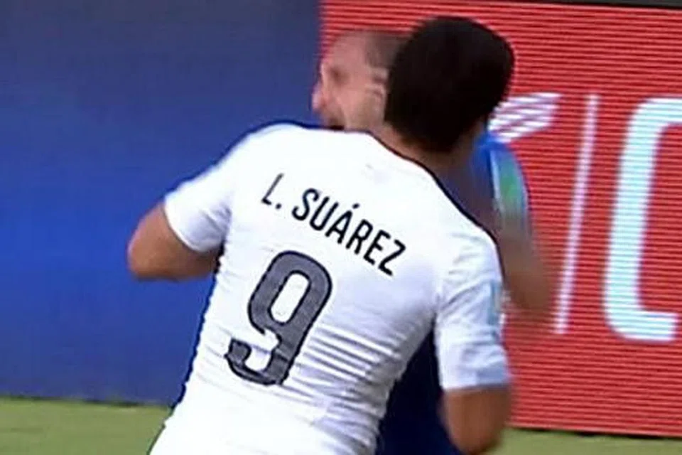 AKSI DIRAKAM DALAM VIDEO: Meskipun tidak dilihat pengadil, rakaman video menunjukkan penyerang Uruguay, Luiz Suarez (jersi putih), menggigit bahagian bahu pemain bek Italy, Giorgio Chiellini pada minit ke-80 perlawanan. - Foto INTERNET