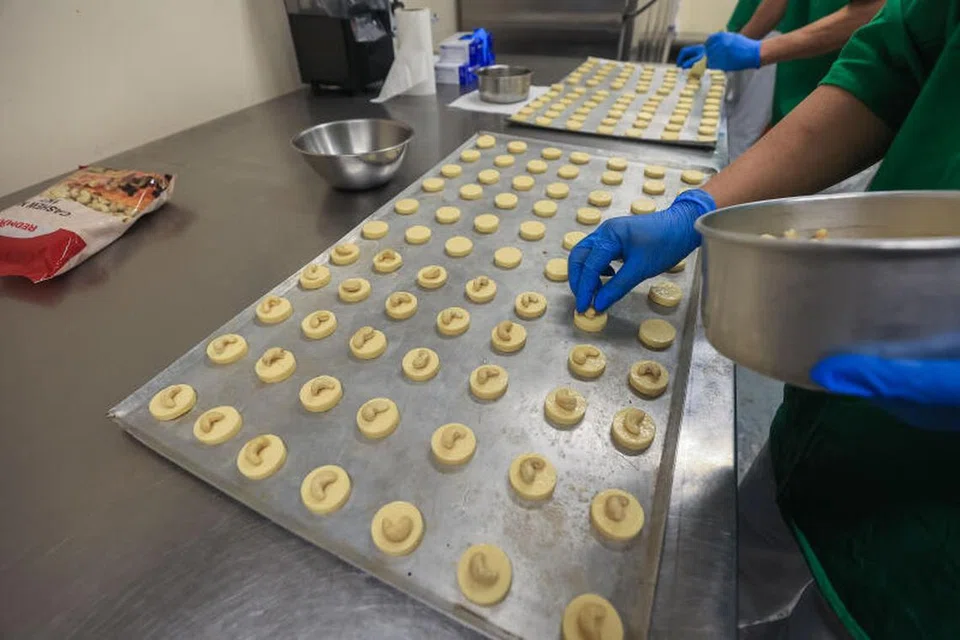 Proses membuat kuih badam, salah satu jenis kuih yang dijual oleh Bakeri Reben Kuning.