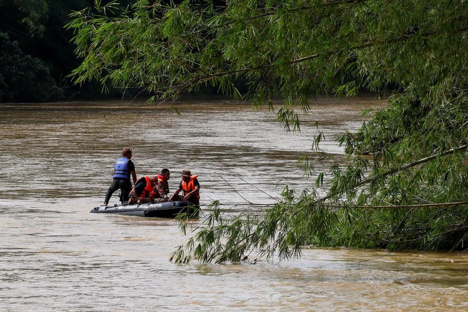 OPERASI MENCARI: Pasukan penyelamat menjalankan operasi mencari mangsa tragedi kepala air di Jeram Air Putih dekat di Kampung Teladas.