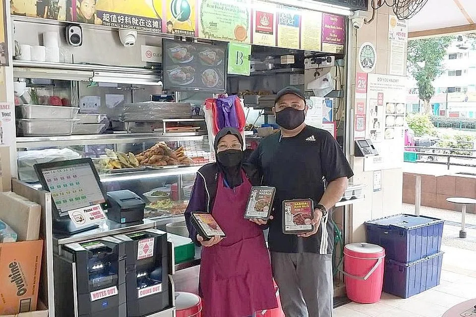 INOVASI SEMASA COVID-19: Pemilik bersama 'Boon Lay Power Nasi Lemak' Hajah Nyonya Mohd Shah dan Encik Shaharizal Ramli menunjukkan produk-produk makanan siap dimakan (RTE) yang dijual di gerai-gerainya. - Foto BOON LAY POWER NASI LEMAK