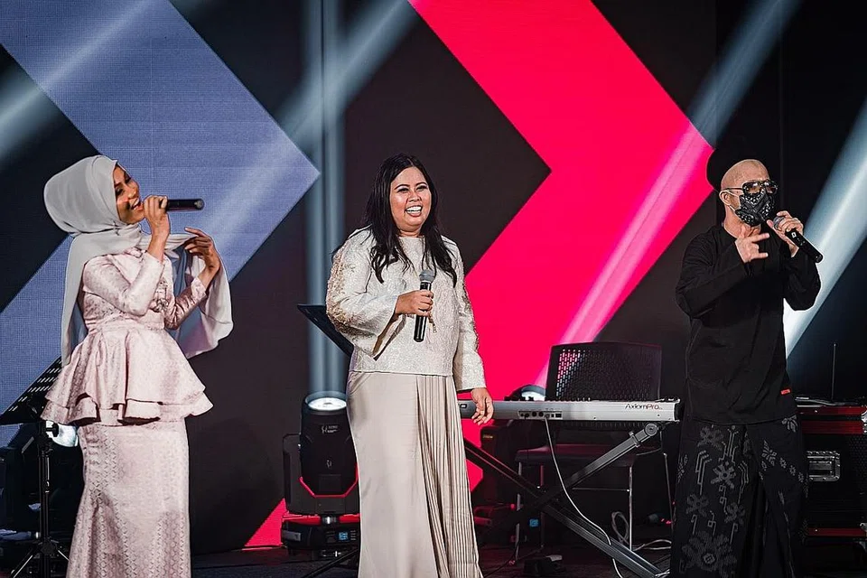 PENGALAMAN BARU: Anggota Parlimen GRC Sembawang, Cik Mariam Jaafar (tengah), yang menggunakan nama pentas 'Kakak MJ' gembira dapat sebar pesanan tentang berpada-pada beraya dalam wabak Covid-19 sambil menyanyi dengan Mawar Berduri (kiri) dan 2KangKata. - Foto MAEC WOODLANDS