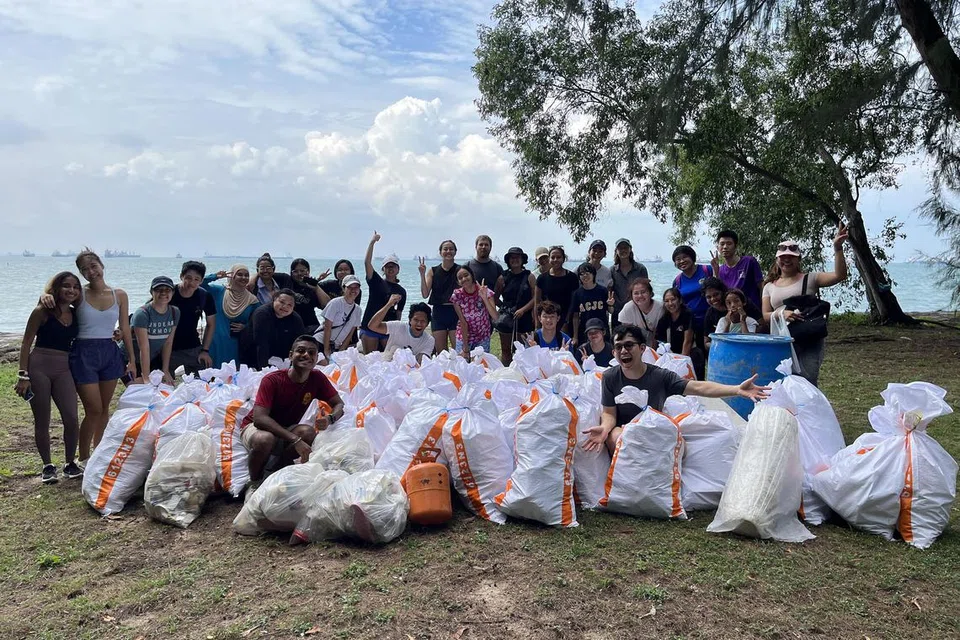 MEMBERSIH PANTAI: Encik Mohamed Yasser Amin Habib (depan, kiri), ketua pegawai Stridy, bergambar bersama penduduk selepas mengutip sampah di pantai Taman East Coast pada 2022.