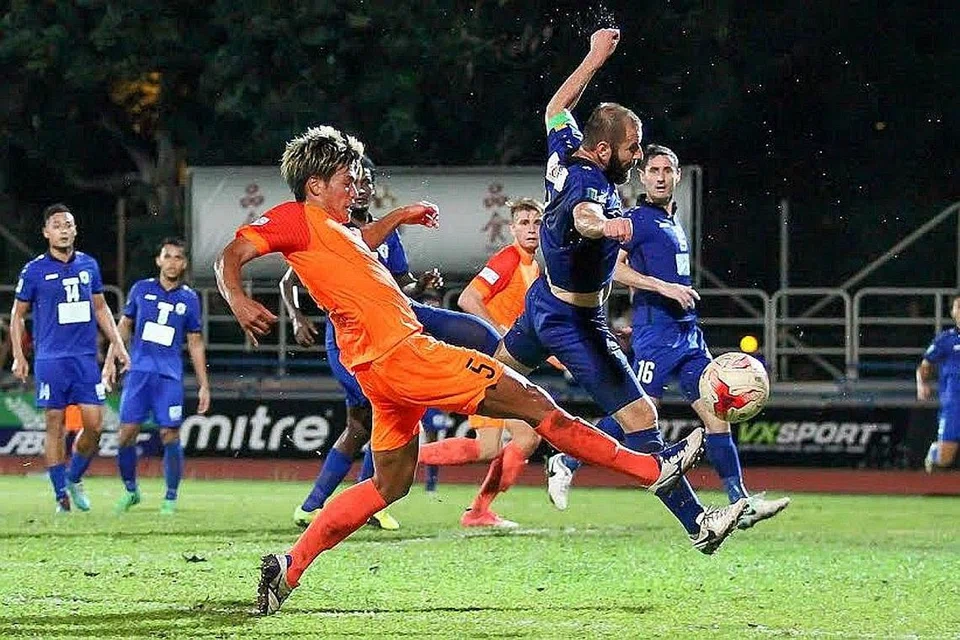 LERAIKAN BAHAYA: Tunggak Tampines, Mustafic Fahrudin (jersi biru), memintas bola daripada sampai kepada pemain Hougang United. - Foto HAIQAL TAHIR