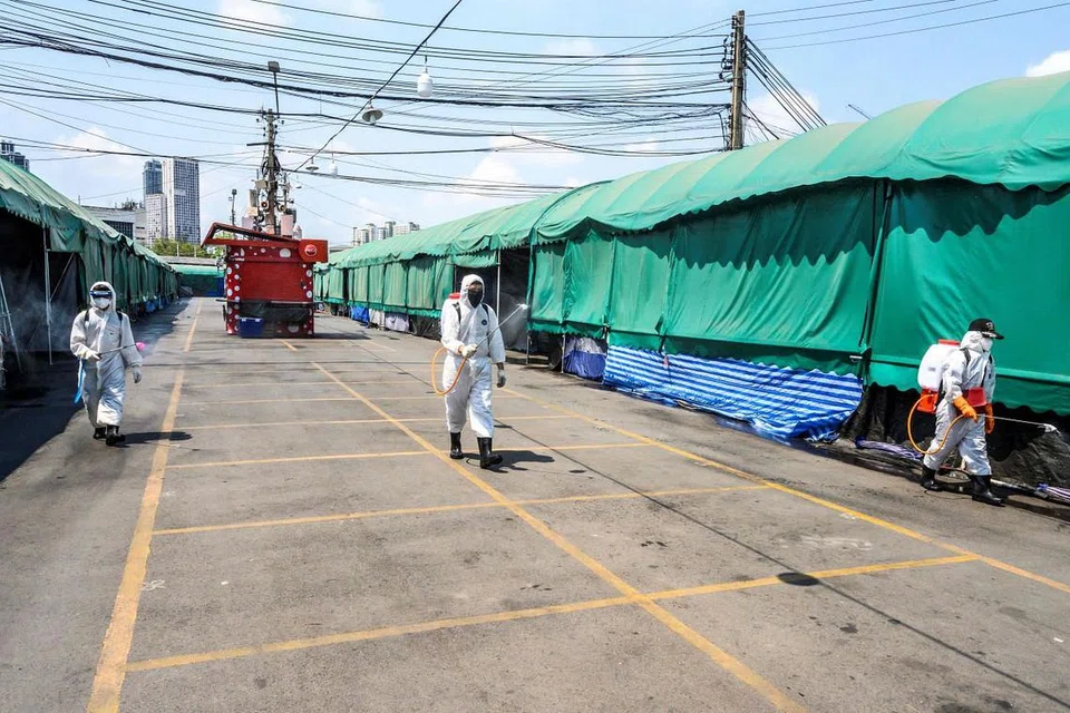 DEKRI DARURAT: Beberapa pekerja kesihatan dengan alat pelindung sedang menjalankan kerja pebasmian kuman di pasar Chatuchak, Bangkok pada 23 Mac 2020. Foto:AFP 