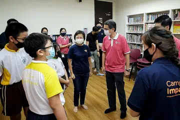 PUSAT RELAWAN BARU: Menteri Negara (Pembangunan Negara merangkap Ehwal Dalam Negeri) Profesor Madya Muhammad Faishal Ibrahim dilihat sedang berinteraksi bersama relawan Cik Lilian Chua ketika dan pelajar penerima program bantuan pembelajaran sewaktu perasmian Pusat Relawan SG Cares di Blok 151 Yishun Street 11 semalam. - Foto ZAOBAO