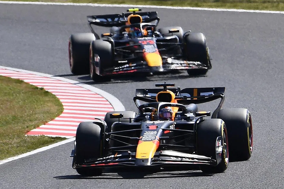 Pemandu kereta lumba Red Bull, Max Verstappen (depan), membelok sembil diekori seorang lagi pemandu sepasukannya, Sergio Perez (belakang), di litar Suzuka, Jepun.