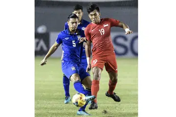 BERTARUNG REBUT TEMPAT: Pemain Thailand Adison Promrak (kiri) merebut bola dengan Khairul Amri dalam perlawanan Piala Suzuki AFF di utara Manila, Filipina, kelmarin. - Foto AFP
