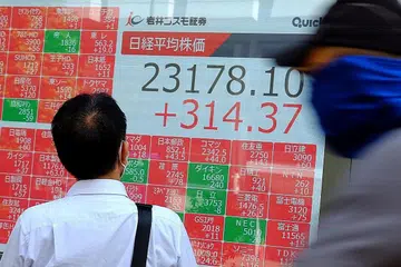 MEROSOT: Seorang pejalan kaki sedang melihat prestasi saham di Bursa Saham Tokyo yang merosot ekoran penjualan besar-besaran kebanyakan syarikat. - Foto AFP