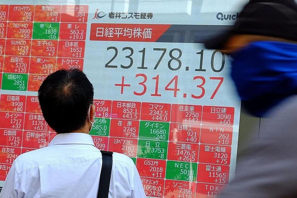 MEROSOT: Seorang pejalan kaki sedang melihat prestasi saham di Bursa Saham Tokyo yang merosot ekoran penjualan besar-besaran kebanyakan syarikat. - Foto AFP
