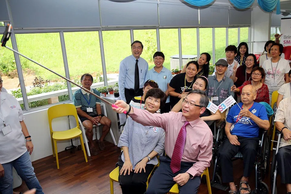 PENDEKATAN HOLISTIK: Encik Gan Kim Yong merakam foto 'wefie' bersama anggota, pengasuh dan relawan Pusat Kesejahteraan Stesen Sokongan Strok (S3). - Foto PUSAT KESEJAHTERAAN STESEN SOKONGAN STROK