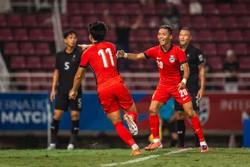 Pemain sayap Singapura, Glenn Kweh (kiri) meraikan gol beliau menentang Thailand dalam perlawanan persahabatan di Stadium Thammasat. Beliau menjaringkan dua gol dalam perlawanan tersebut, tetapi Thailand tetapi berjaya memenangi perlawanan dengan keputusan  3-2.