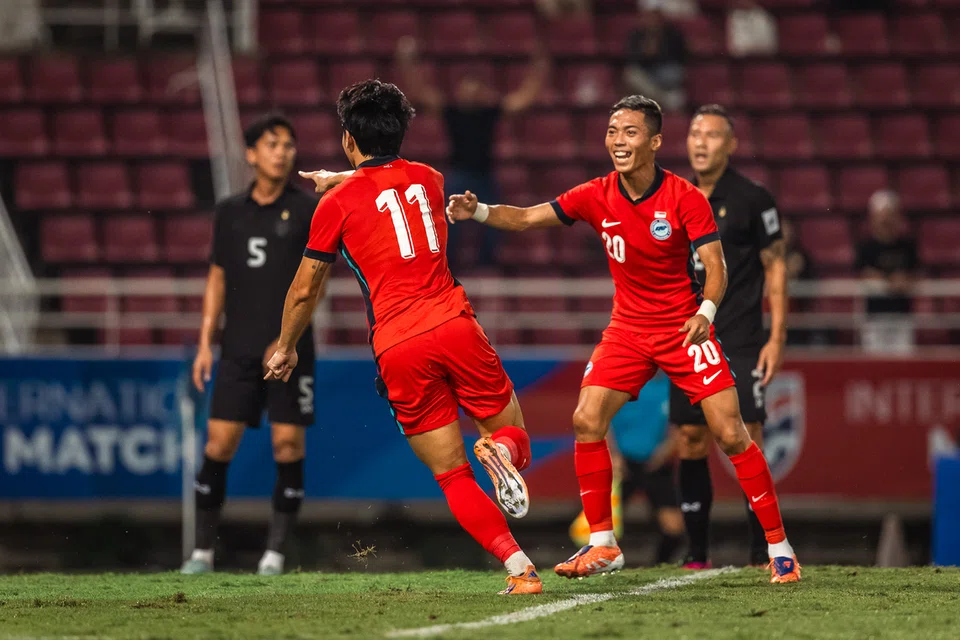 Pemain sayap Singapura, Glenn Kweh (kiri) meraikan gol beliau menentang Thailand dalam perlawanan persahabatan di Stadium Thammasat. Beliau menjaringkan dua gol dalam perlawanan tersebut, tetapi Thailand tetapi berjaya memenangi perlawanan dengan keputusan  3-2.