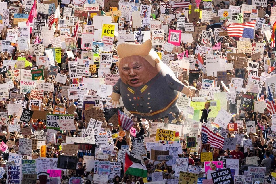 (FOTO FAIL) Penunjuk perasaan memegang sepanduk, bendera serta belon besar bergambar Presiden Amerika Syarikat Donald Trump semasa demonstrasi nasional “Hands Off!” yang membantah Trump dan penasihatnya, Ketua Pegawai Eksekutif Tesla Elon Musk, di pusat bandar Los Angeles pada 5 April 2025. Setahun memasuki penggal keduanya, Trump dilihat merombak susunan dunia pasca Perang Dunia Kedua secara paling ketara, sehingga meninggalkan dunia yang mungkin tidak lagi dikenali selepas tempoh pemerintahannya. Jauh daripada memperlahankan langkah, Trump memulakan tahun baharu dengan deretan tindakan agresif yang secara terbuka mencabar tatanan berdekad-dekad lamanya yang sebelum ini dipelopori oleh Amerika Syarikat. 