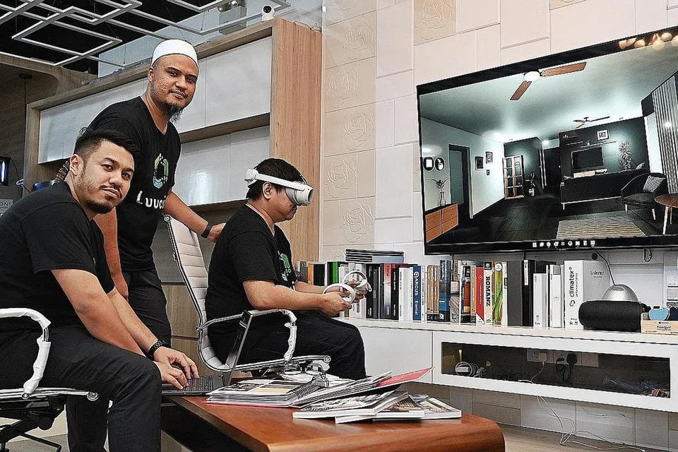 GUNA VR: (Dari kiri) Encik Muhd Fauzi dan Encik Muzhaffa Kamal, bersama salah seorang pekerjanya mereka yang menunjukkan cara penggunaan teknologi VR dalam khidmat yang ditawarkan kepada pengguna. - Foto BH oleh KHALID BABA