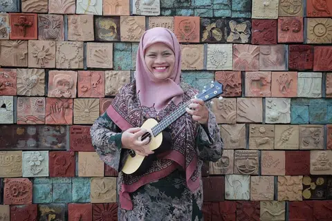 BERSEMANGAT: Cik Rohani bersyukur walaupun sakit, beliau tetap bersemangat memburu ilmu pengetahuan termasuk muzik. - Foto BH oleh JASON QUA