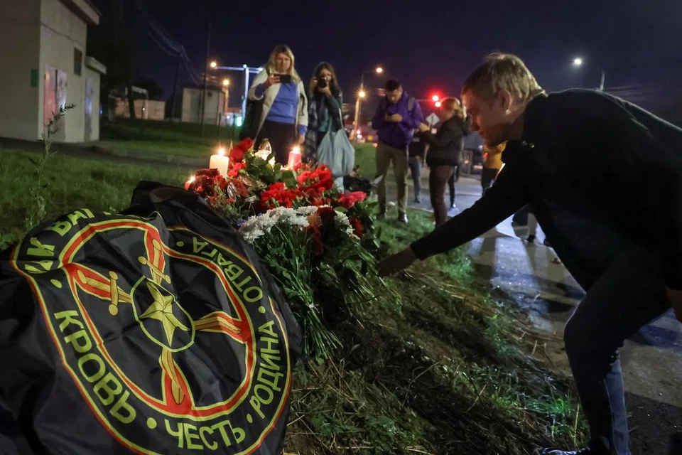 PERINGATI KEMATIAN: Seorang lelaki meletakkan jambangan bunga bagi memperingati ketua kumpulan askar upahan Wagner, Encik Yevgeny Prigozhin, di hadapan Pusat PMC Wagner di St Petersburg, Russia pada Khamis.