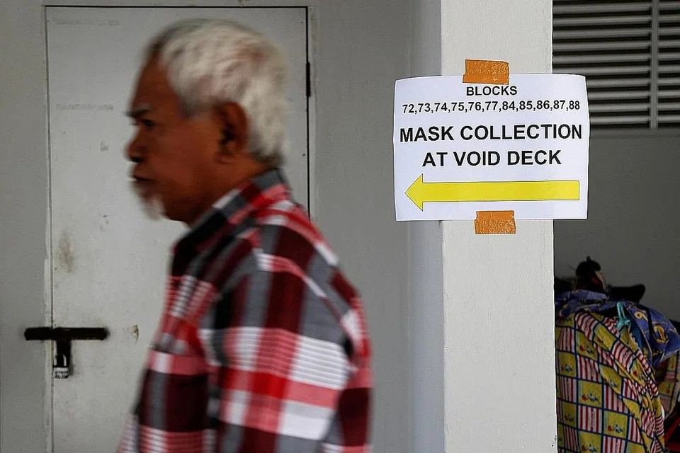 LANGKAH PENCEGAHAN: Usaha mengagihkan pelitup percuma kepada rakyat Singapura telah turut diadakan di bawah kolong blok. - Foto REUTERS