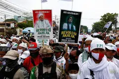 MASIH BERPENGARUH: Para pengikut dan penyokong Habib Rizieq berarak beramai-ramai sambil membawa sepanduk 'Revolusi Akhlak' sebagai tanda penghormatan menyambut kepulangan pemimpin itu pada 10 November lalu dengan kawalan rapi polis. - Foto REUTERS