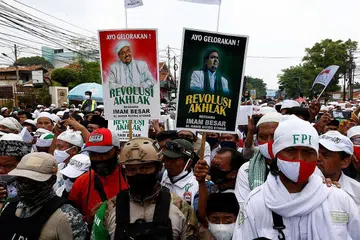 MASIH BERPENGARUH: Para pengikut dan penyokong Habib Rizieq berarak beramai-ramai sambil membawa sepanduk 'Revolusi Akhlak' sebagai tanda penghormatan menyambut kepulangan pemimpin itu pada 10 November lalu dengan kawalan rapi polis. - Foto REUTERS