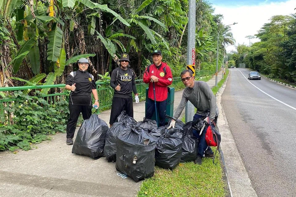 JAGA KEBERSIHAN: Pendaki dari Team Jalan Santai, (dari kiri) Ustaz Jakfar Embek, Ustaz Bahrul-Ulum, Ustaz Raja Muzaffar dan Encik Azmi bersama sebahagian beg plastik yang berisi sampah sarap yang dikutip dari Istana Woodneuk tidak jauh dari Kebun Bunga Singapura. - Foto TEAM JALAN SANTAI