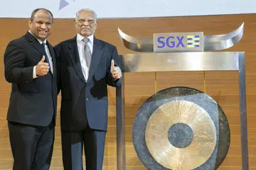 BERSAMA BAPA TERCINTA: Encik Ismail (kiri) bersama bapanya, Encik Abdul Gafoore Mohamed Kassim, yang turut sama mengetuk gong di SGX bagi menandakan penyenaraian saham PropNex di bursa saham. - Foto PROPNEX