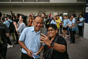 Naib Pengerusi WP dan ketua pasukan WP di GRC Tampines, Encik Faisal Manap, bergambar bersama penduduk di luar Tampines One pada 30 April.