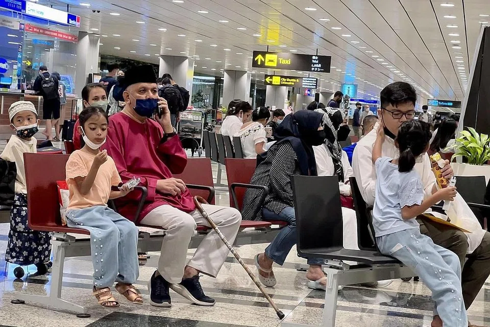 SABAR MENANTI: Anggota keluarga, sanak saudara dan rakan-rakan tiba seawal 7 malam untuk menyambut ketibaan para jemaah. Kumpulan pertama jemaah Singapura itu mendarat di Lapangan Terbang Changi sekitar 8 malam Sabtu lalu.