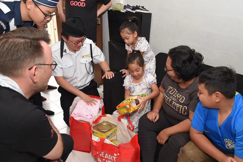 Kembar Nur Dina Shazia Muhammad Sarifee dan Nur Dina Shaista Muhammad Sarifee, 4 tahun, yang mengikuti program KidSTART, menerima hamper yang mengandungi barangan mesra kanak-kanak. FOTO: BBSG