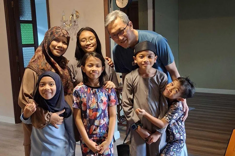Cik Amiliah Basri (barisan belakang, kiri) dan Encik Abu
Bakar Hassan (barisan belakang, kanan) terkenang saat berinteraksi bersama anak-anak jiran mereka yang dianggap sebagai cucu sendiri. 