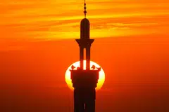 Pancaran suria di balik menara masjid yang menakjubkan dan membawa pelbagai perasaan dan kerinduan (gambar hiasan).