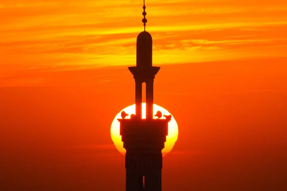 Pancaran suria di balik menara masjid yang menakjubkan dan membawa pelbagai perasaan dan kerinduan (gambar hiasan).