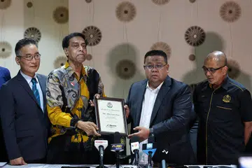 SAAT MERCU TANDA: Setiausaha agung Persekutuan Sepak Takraw Antarabangsa (Istaf), Abdul Halim Kader (dua dari kiri) menyampaikan sijil pelantikan naib presiden Istaf kepada presiden Persatuan Sepak Takraw Malaysia (PSM), Mohd Sumali Reduan, di sebuah hotel di Kuala Lumpur pada 9 Januari.
