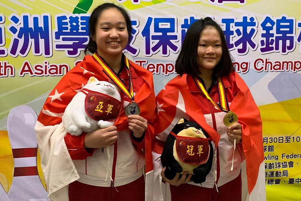 KEPUTUSAN MEMBANGGAKAN: (dari kiri) Arianne Tay dan Shin Zong Yi berjaya mengharumkan nama negara selepas meraih dua kedudukan teratas di Kejohanan Tenpin Bowling Sekolah Asia ke-19 di Taichung, Taiwan baru-baru ini. - Foto PERSEKUTUAN BOWLING SINGAPURA