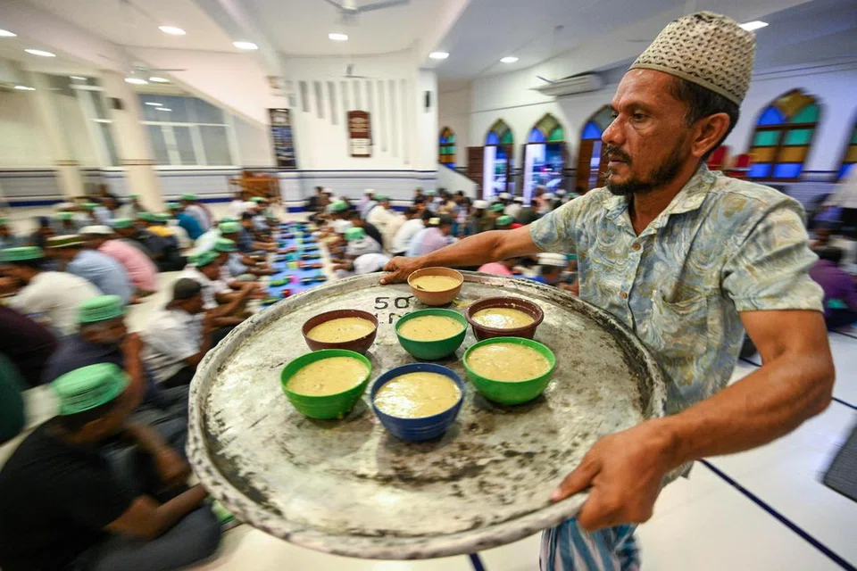 Seorang anggota jemaah mengagihkan makanan sebagai persiapan untuk berbuka puasa di Masjid Jumma pada hari pertama Ramadan di Colombo pada 12 Mac.