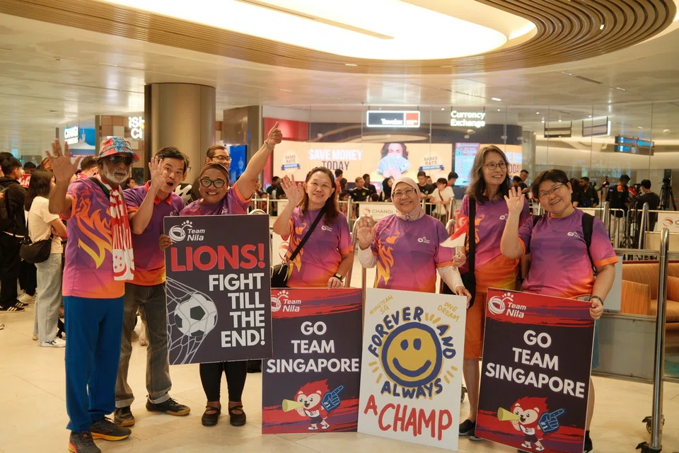 Sukarelawan Team Nila, turut menjemput kepulangan pemain bola sepak negara di Lapangan Terbang Changi pada 19 November. Berada dalam gambar ialah Cik Suzanna Gunawi, (tiga dari kanan). 