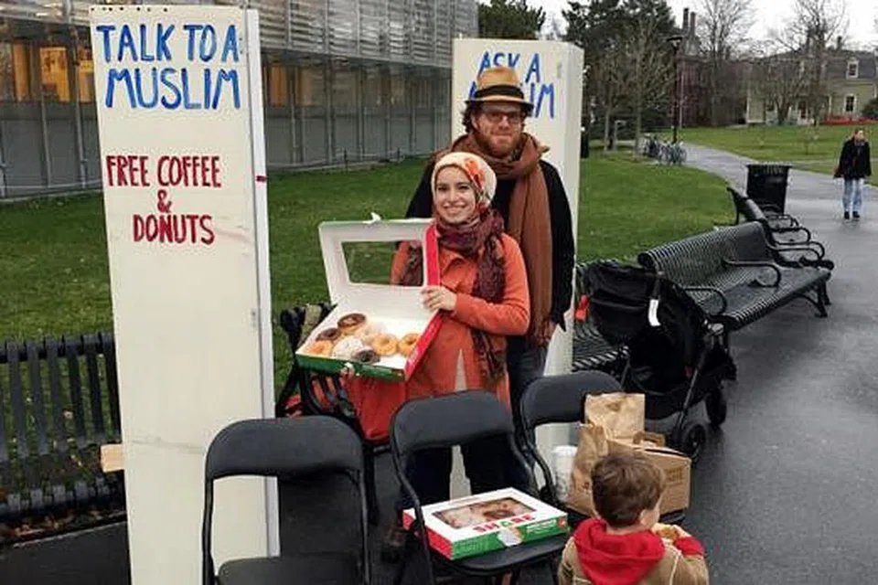 INGIN KONGSI TENTANG ISLAM: Cik Mona dan suaminya, Encik Robins, berdiri di samping dua papan tanda dan mereka hanya ingin bersembang dan membetulkan salah tanggapan tentang Islam dalam kalangan rakyat Amerika. - Foto ihsan MONA HAYDAR
