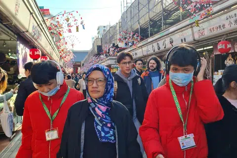 Kembar Yousef Asir Zulkefli (kiri) dan Yousef Asif Zulkefli berjalan-jalan di Jepun menggunakan lanyard kurang upaya dan fon kepala bersama ibu mereka, Cik Nor Hafizah Abdul Ghani. 
