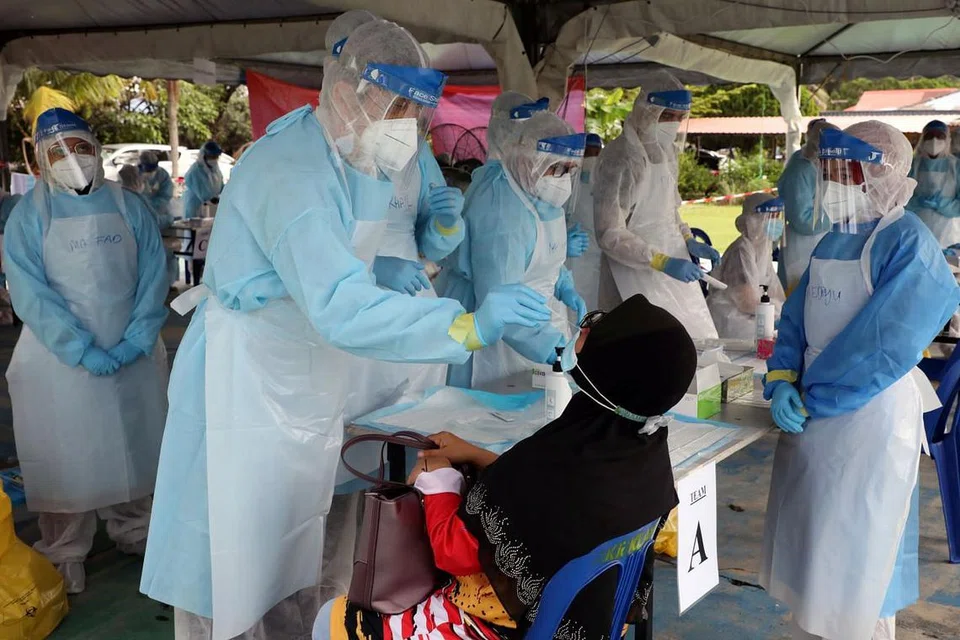 Seorang pegawai kesihatan dilihat sedang menjalankan ujian swab kepada seorang wanita di Klang pada 2 Disember 2020. - FOTO: REUTERS