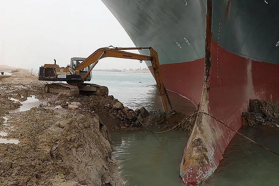 USAHA BERTERUSAN: Gambar yang dikeluarkan oleh Penguasa Terusan Suez menunjukkan usaha mesin pengorek membawa keluar pasir dari sekeliling kapal MV Ever Given (Evergreen), yang terkandas dan menghalang semua lalu lintas melintasi Terusan Suez di Mesir. - Foto AFP